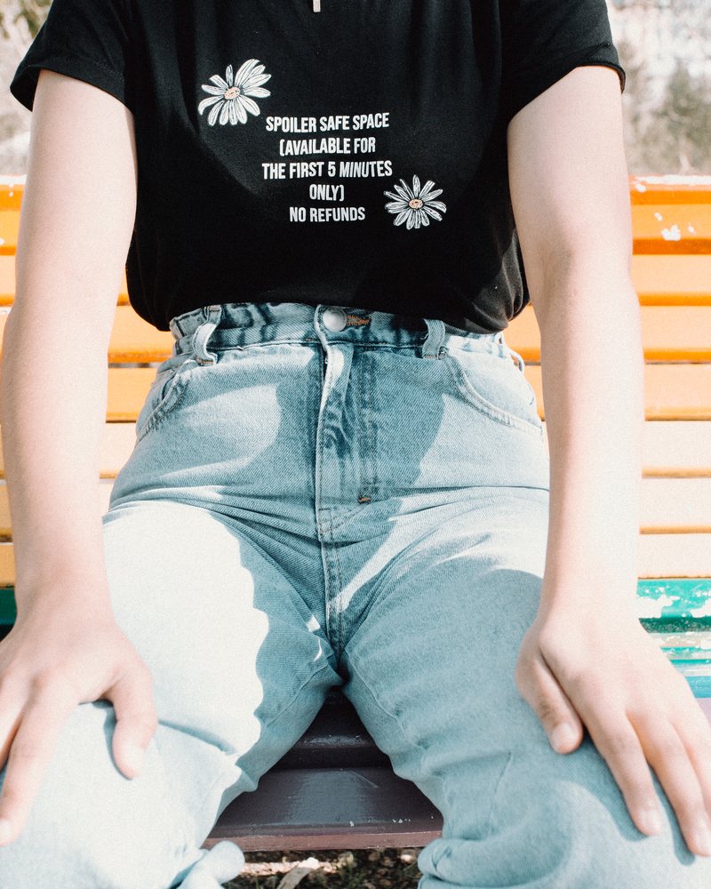 Schwarzes bedrucktes T-Shirt mit Blumenmotiv, kombiniert mit heller Jeans